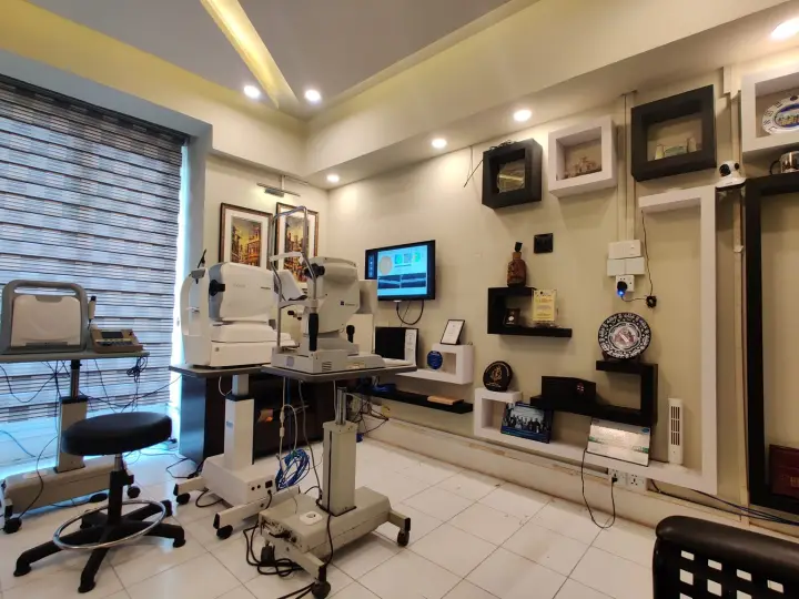 Examination room with an auto-refractometer, a slit lamp and a vision chart screen.