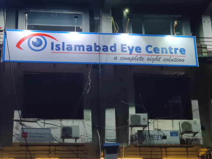 The clinic sign on the front of Rashid Plaza at night.